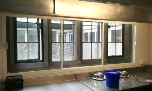 A white sliding fly screen in a commercial kitchen