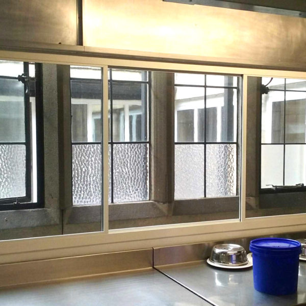 A white sliding fly screen in a commercial kitchen