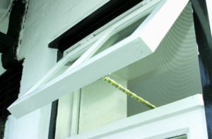 A white chain winder fly screen opened on a window