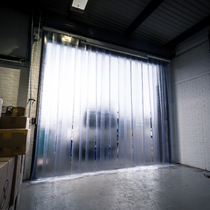 A sliding pvc curtain installed to a roller shutter door in a warehouse