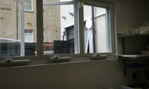 Three white screen and chain winder fly screens on kitchen windows