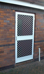 Exterior view of closed fly screen door in a brick building