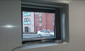 White flexicon screen installed to window in office with blinds in the way