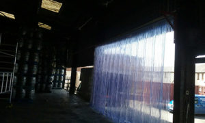 Sliding curtain installed in warehouse with beer kegs