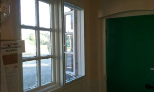 White fly screen next to a green door