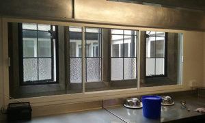 White sliding fly screen door in a commercial kitchen