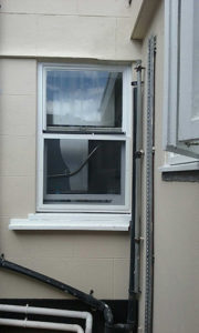 White fly screen installed externally to window on building