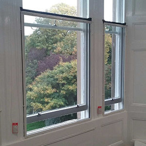 White fly screen installed over a sash metal window