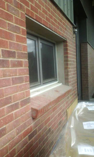 External image of a fly screen installed to a window with a brick building