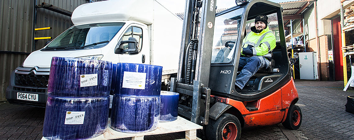 Technician on forklift truck moving pvc rolls on a pallet