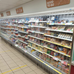 A supermarket aisle with PVC strips in front of the food items to protect