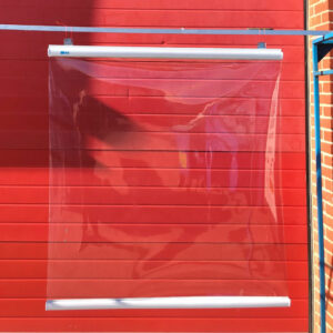 A processed image of a pvc chiller strip hanging outside a red roller shutter door