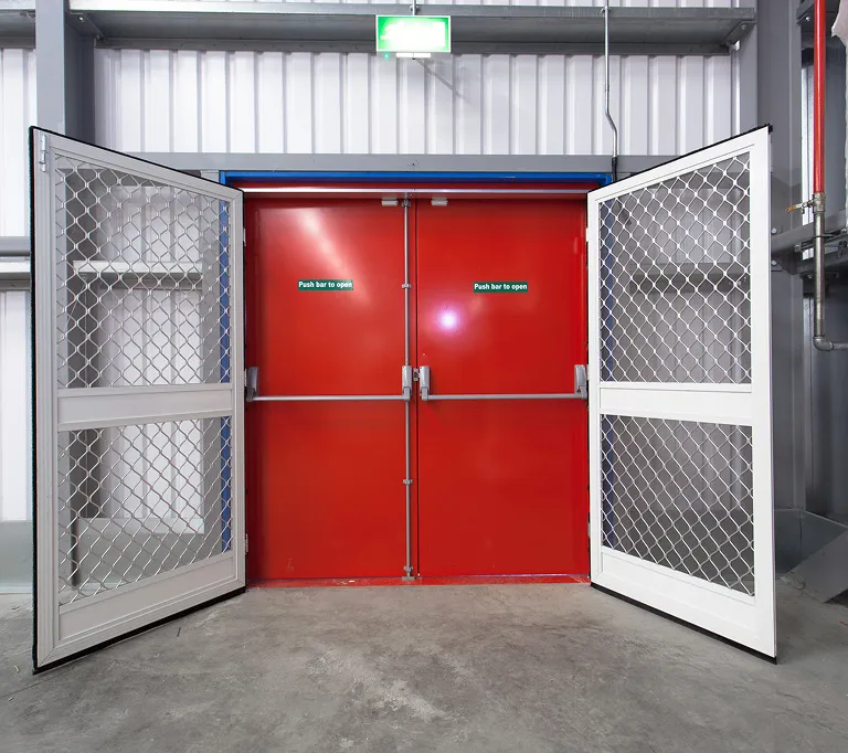 Fly screen doors used within a warehouse setting alongside a fire exit