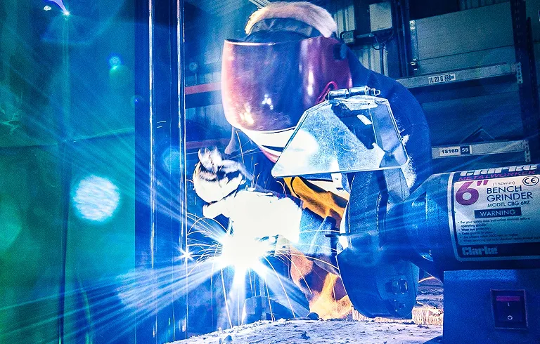 Worker welding in a warehouse